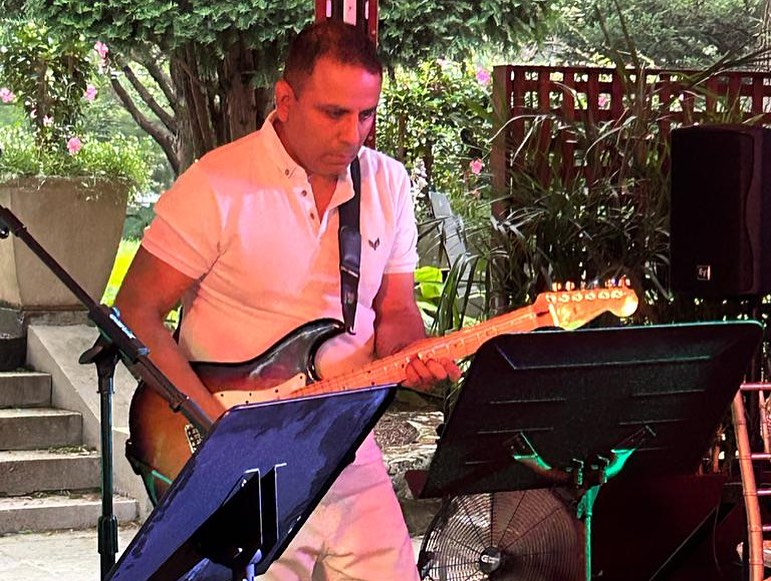 man wearing white shirt and playing electric guitar